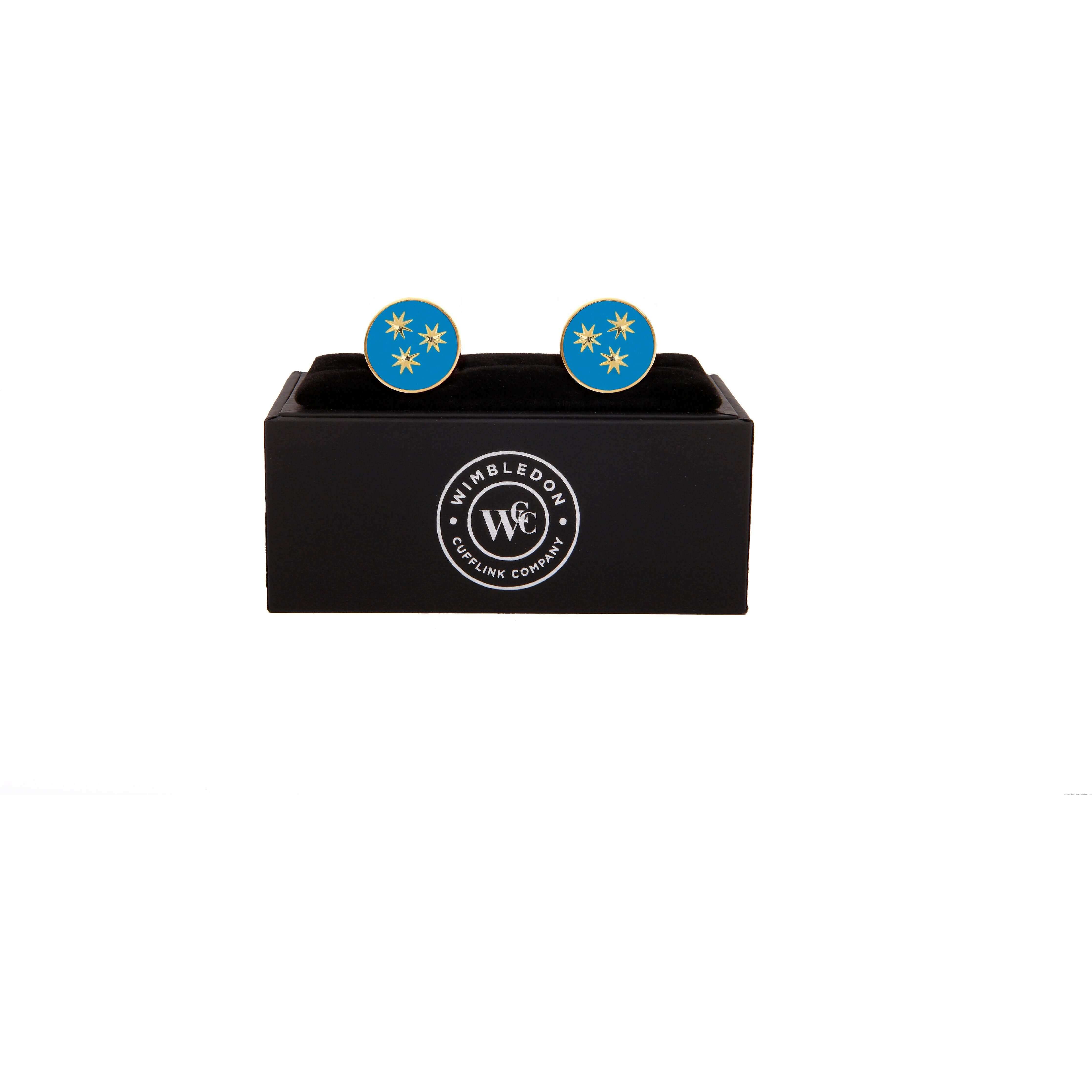 Limited edition St Philip Neri cufflinks with light blue enamel and golden stars, supporting Bromton Oratory, displayed on a black box.