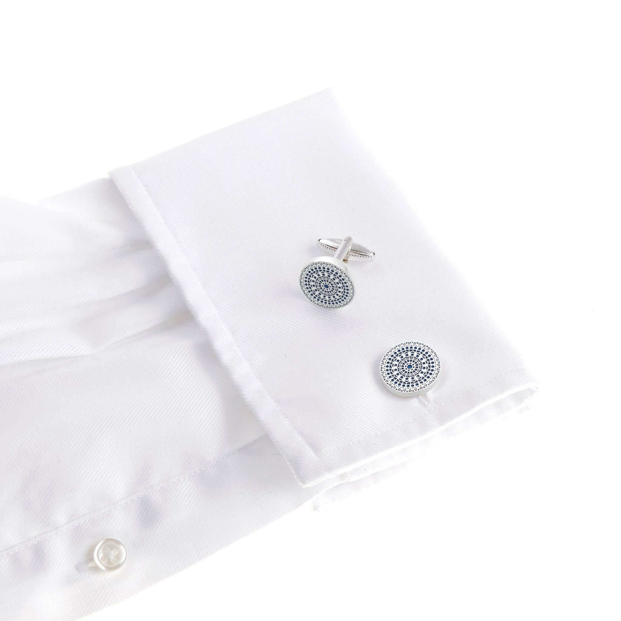 The Rose of Notre Dame silver cufflink featuring a sky blue circular gothic window design on a white dress shirt.