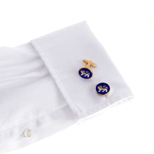 The English Leopard Gold Cufflink with a blue and gold lion design on a white dress shirt cuff